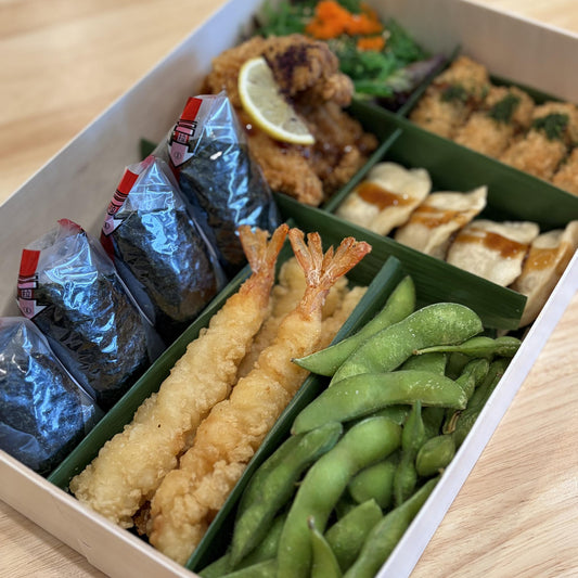 Savory Platter: onigiri, prawns, karaage, gyoza, kaki furai, seaweed salad and edamame in a wooden box